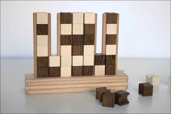 Holzklötze in verschiedenen Farben auf einer Holzbasis, teilweise aufgestellt, teilweise umgestürzt.