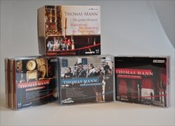 Vier CDs und ein Buch mit Thomas Mann, alle auf einem weißen Tisch.
