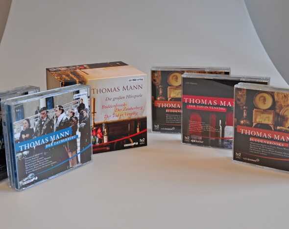 Zwei CDs, eine CD-Hülle und ein Buch von Thomas Mann auf weißem Tisch.