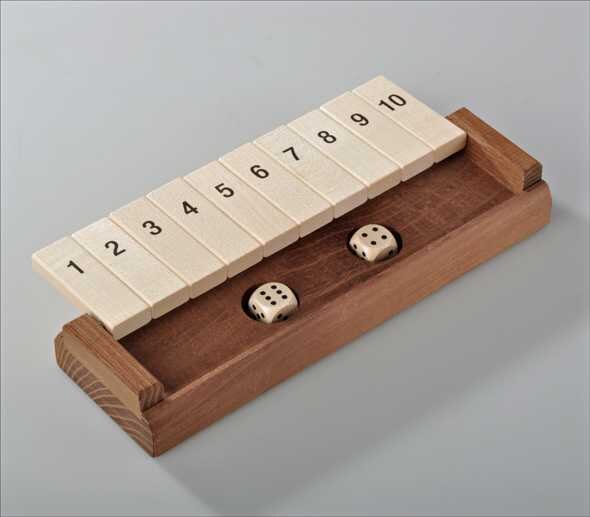 Holz-Mahjong-Spiel mit nummerierten Steinen und zwei Würfeln auf einem Holzbrett.