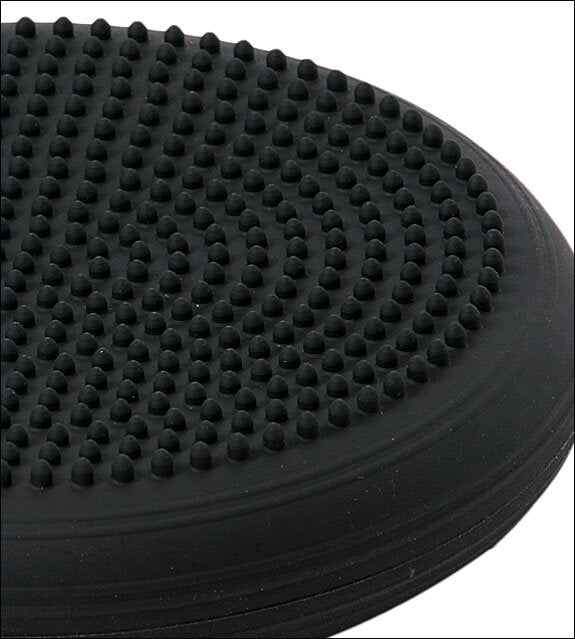 Schwarze, runde Gummipuffer auf einer schwarzen Oberfläche, vermutlich eine rutschfeste Unterlage oder Matten.