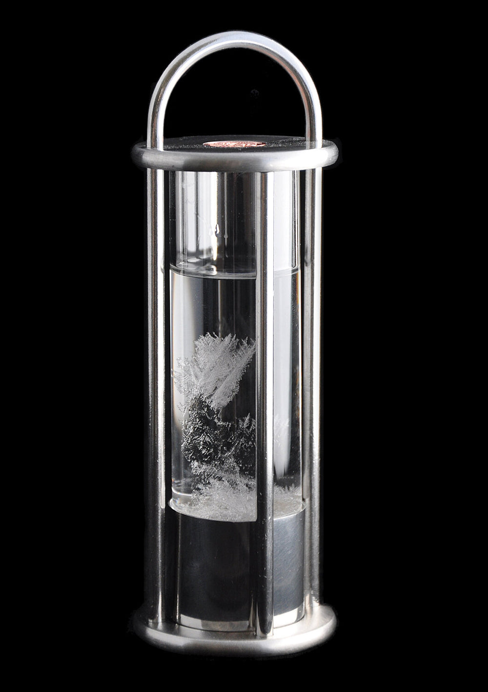 Vakuum-Kristalle im Wasser, eingeschlossen in einem Glasbehälter mit Metallrahmen.