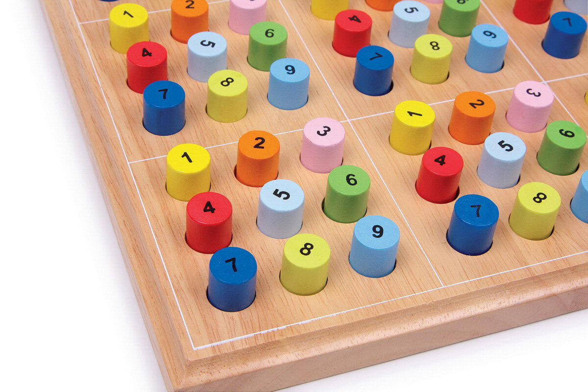 Bunte Holzspiel mit nummerierten, farbigen Zylindern auf einem Spielbrett.