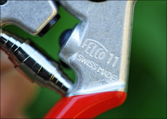 Nahaufnahme eines Metallteils mit der Aufschrift "FETIC 11 SWISS MADE" und rotem Griff.