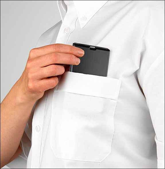 Person steckt Smartphone in die Brusttasche eines weißen Hemdes.