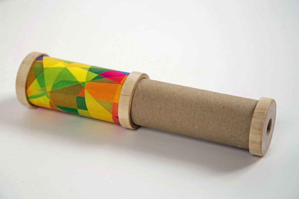 Holz-Kanone mit bunter, geometrischer Musterfolie und braunem Papierrohr.