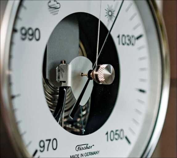 Nahaufnahme eines Barometers mit Zeiger, Skala von 970 bis 1050 hPa, Hersteller Fischer, Made in Germany.
