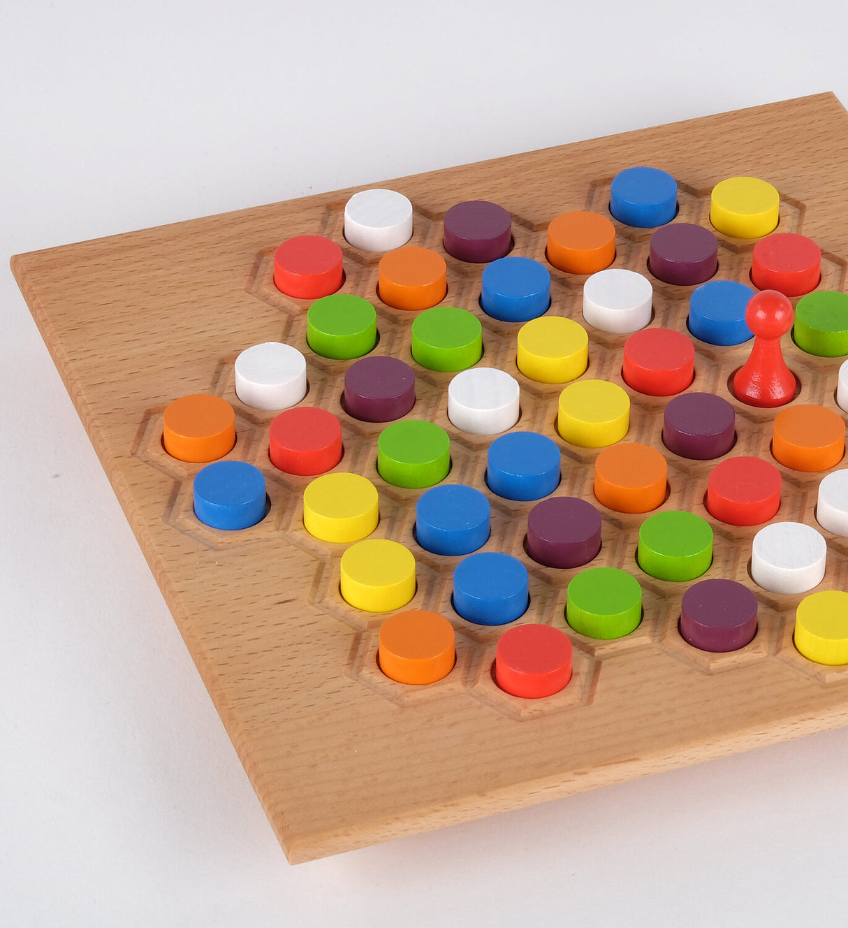 Brettspiel mit bunten runden Spielsteinen auf Holzbrett, einige Steine sind in Vertiefungen.