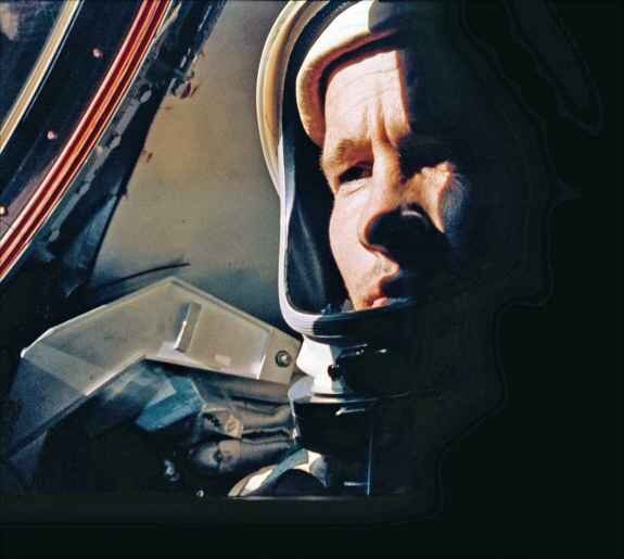 Mann im Raumanzug schaut durch das Fenster eines Flugzeugs.