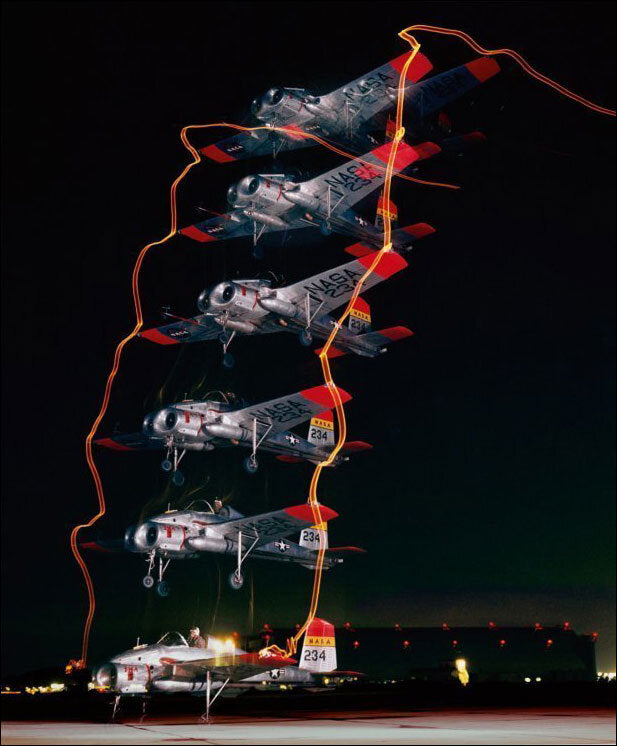 Mehrere F-4 Phantom Jets in Flugformation bei Nacht, mit Licht- und Bewegungsspuren.