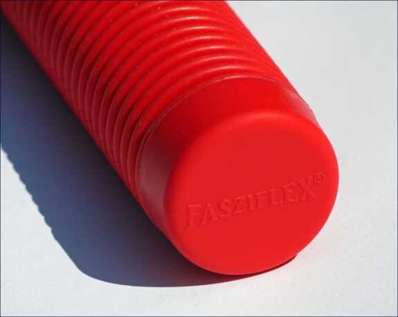 Roter, geriffelter Gegenstand mit "FASZITLEX" auf der runden Unterseite, liegt auf weißem Hintergrund.