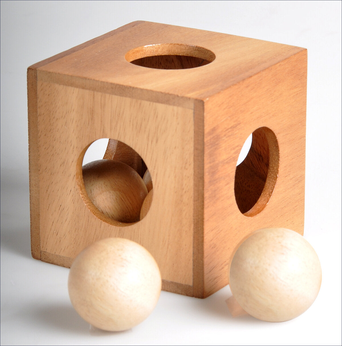 Holzquader mit runden Löchern und zwei Holzklötze davor.