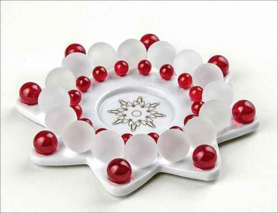 Rundes Spiel mit weißen und roten Kugeln auf einer weißen, sternförmigen Basis.