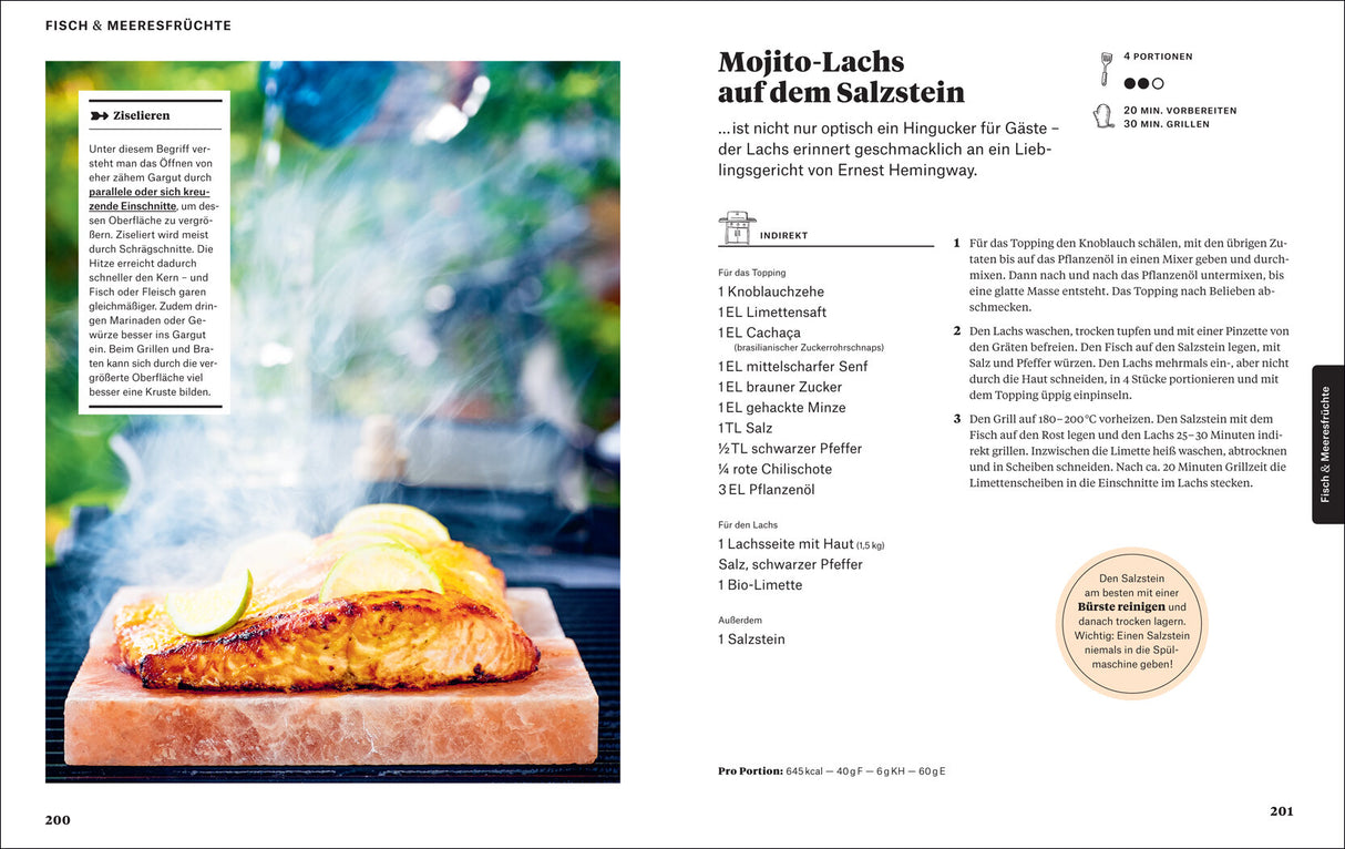 Blick auf ein gebratenes Lachsfilet auf Salzstein mit Zitronenscheiben, Rauch steigt auf, im Hintergrund eine Grillkulisse.