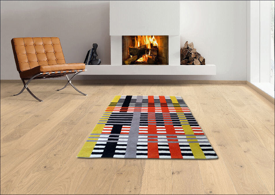 Moderner Raum mit Kamin, braunem Sessel, buntem geometrischem Teppich auf Holzboden.