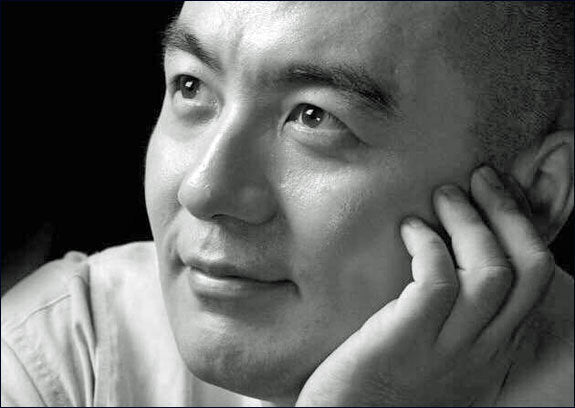 Schwarz-weißes Portrait eines Mannes, der nachdenklich zur Seite schaut, mit Hand an seinem Gesicht.