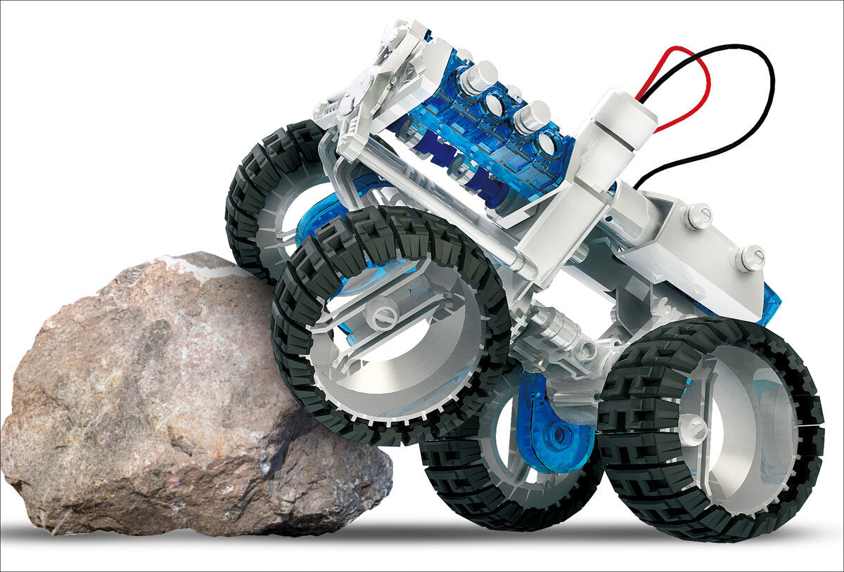 Roboter mit großen Rädern, das einen Stein berührt, aus LEGO-Teilen gebaut.