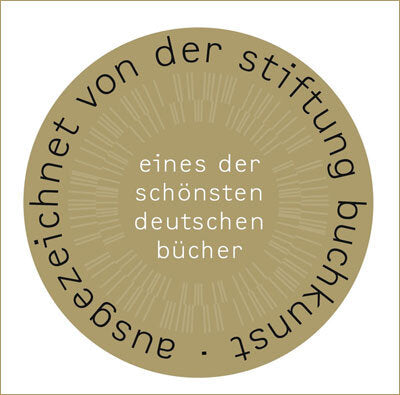 Goldener Kreis mit schwarzem Text: "eines der schönsten deutschen Bücher" und "ausgezeichnet von der Stiftung Buchkunst".