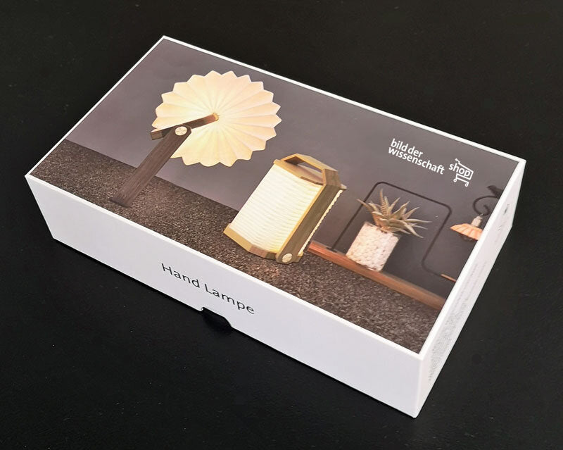 Schwarze Box mit Bild von drei Handlampen, darunter Text "Hand Lampe".