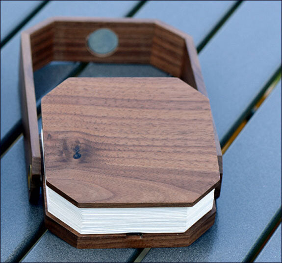 Holzbriefkasten mit Deckel und Briefen, auf einer blauen Oberfläche.