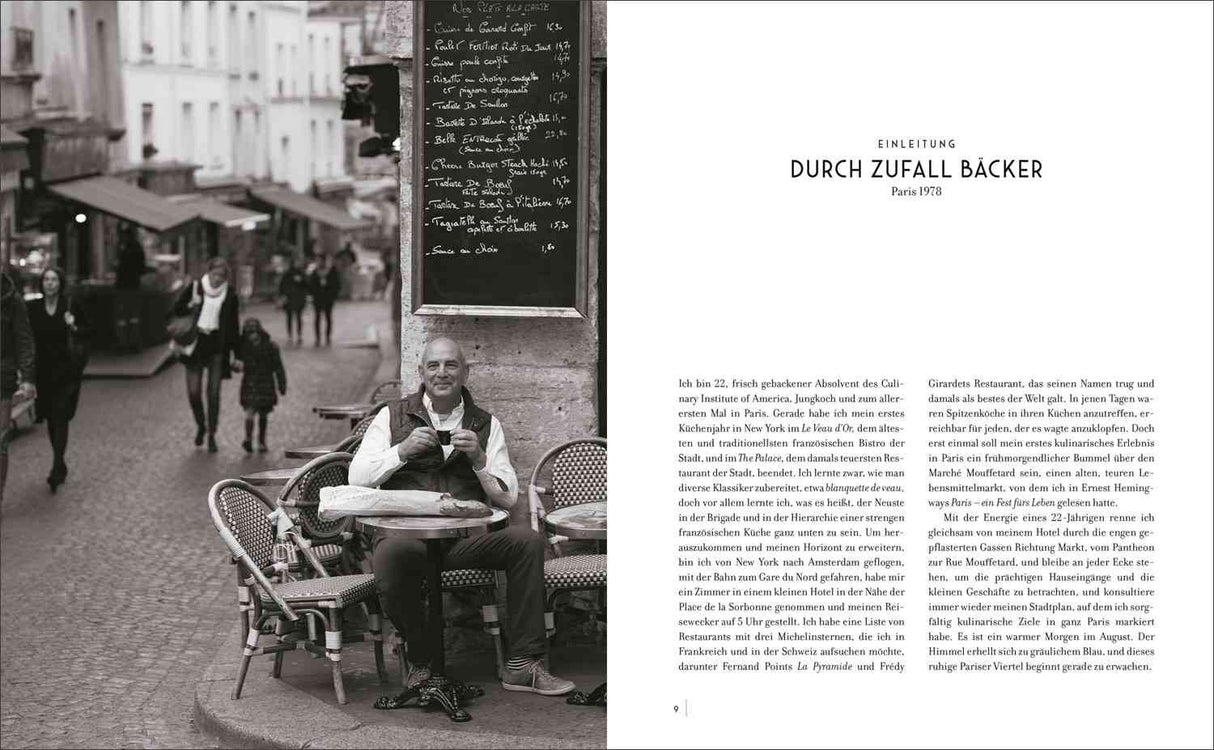 Schwarz-weißes Bild einer Straßencafé-Szene in Paris mit einem Mann, der an einem Tisch sitzt, und einem schwarzen Brett