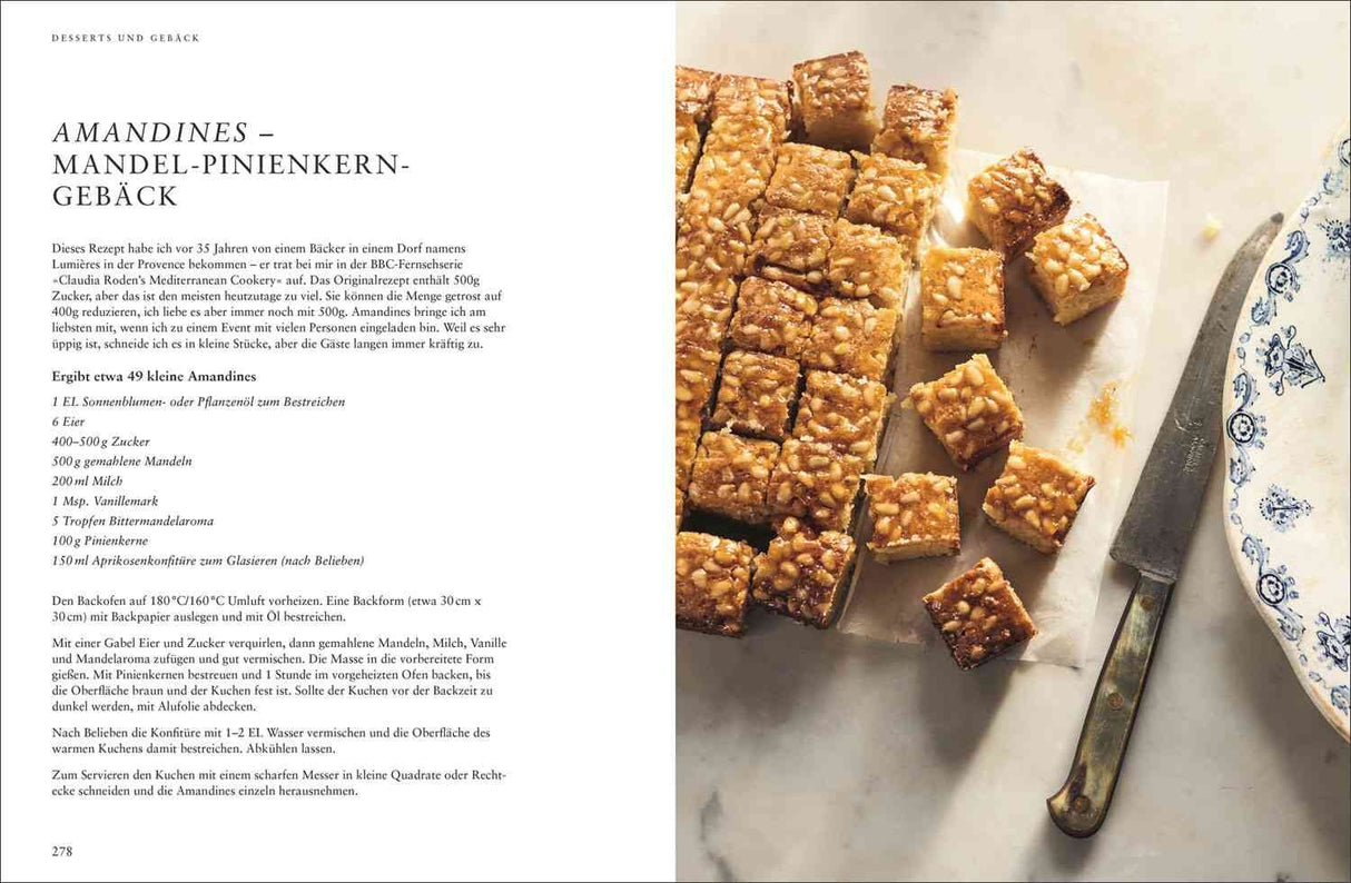 Bunte Mandel-Pinienkerne-Gebäcke in Würfeln auf Backpapier, daneben ein Messer mit Holzgriff.