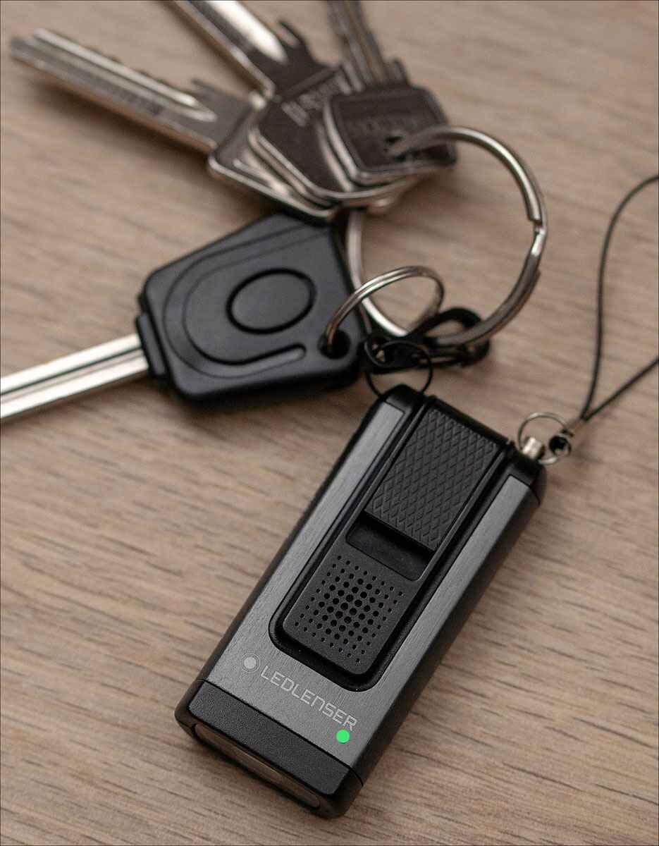 Schlüssel, Schlüsselanhänger, LED-Lenser Taschenlampe, auf Holzuntergrund.