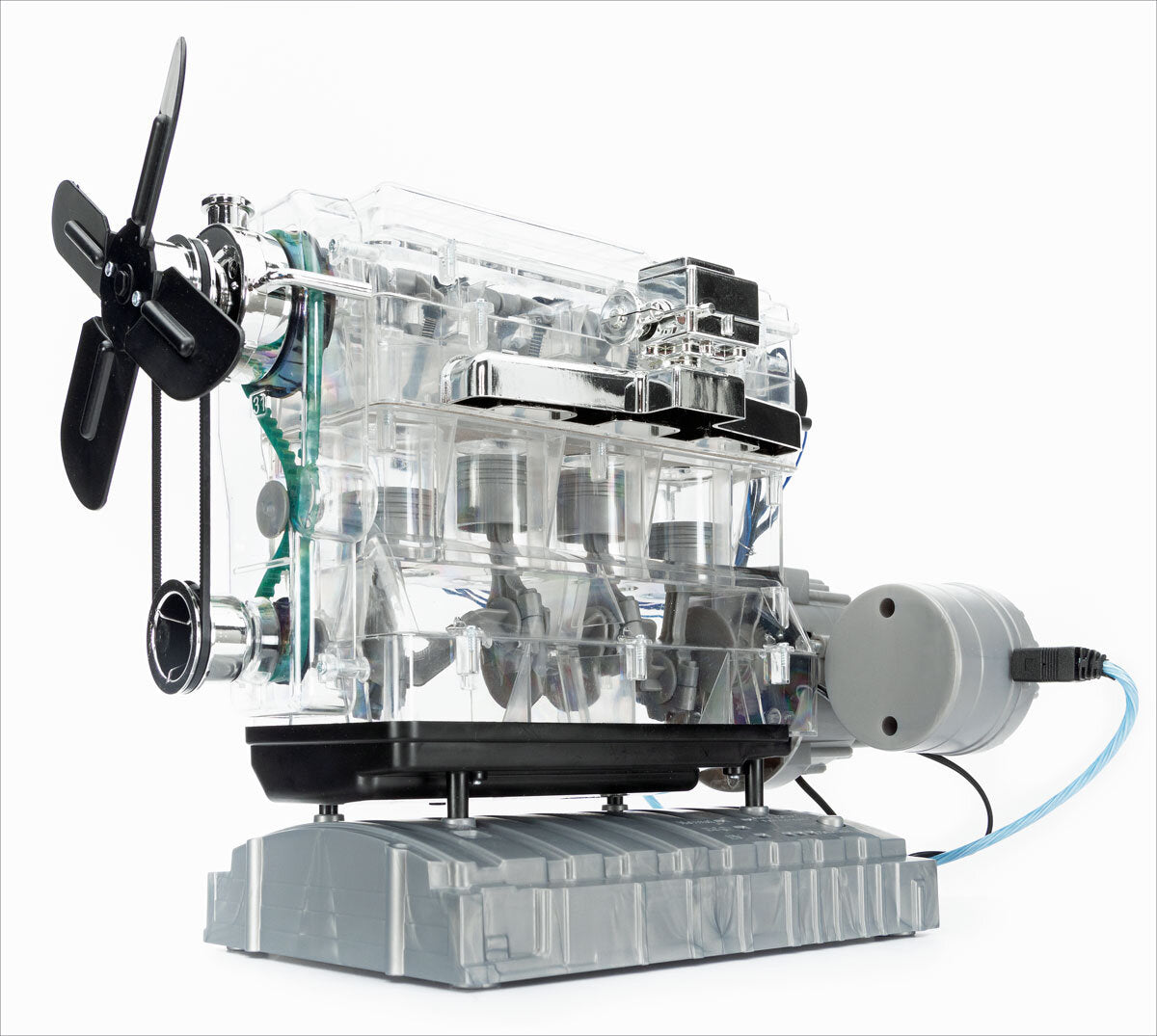 Transparentes mechanisches Gerät mit Propeller, Motor und Kabel auf grauem Sockel.