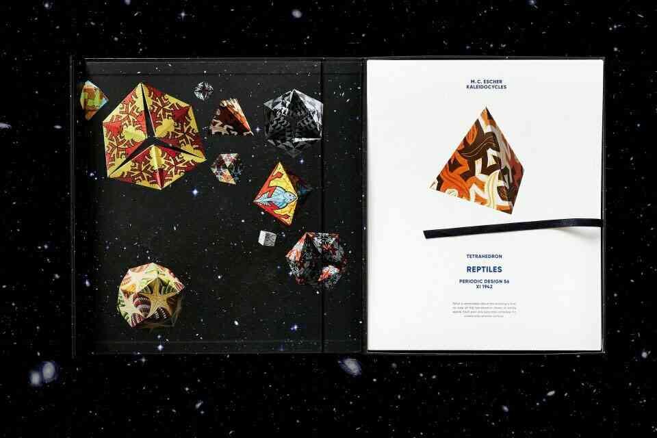 Buch mit bunten, geometrischen Origami-Polyedern auf schwarzem, sternenähnlichem Hintergrund.