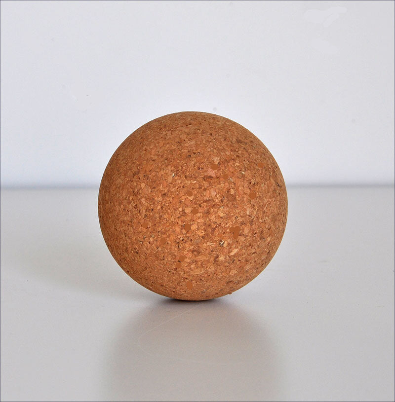 Korkkugel auf weißem Hintergrund, rund und braun mit strukturierter Oberfläche.