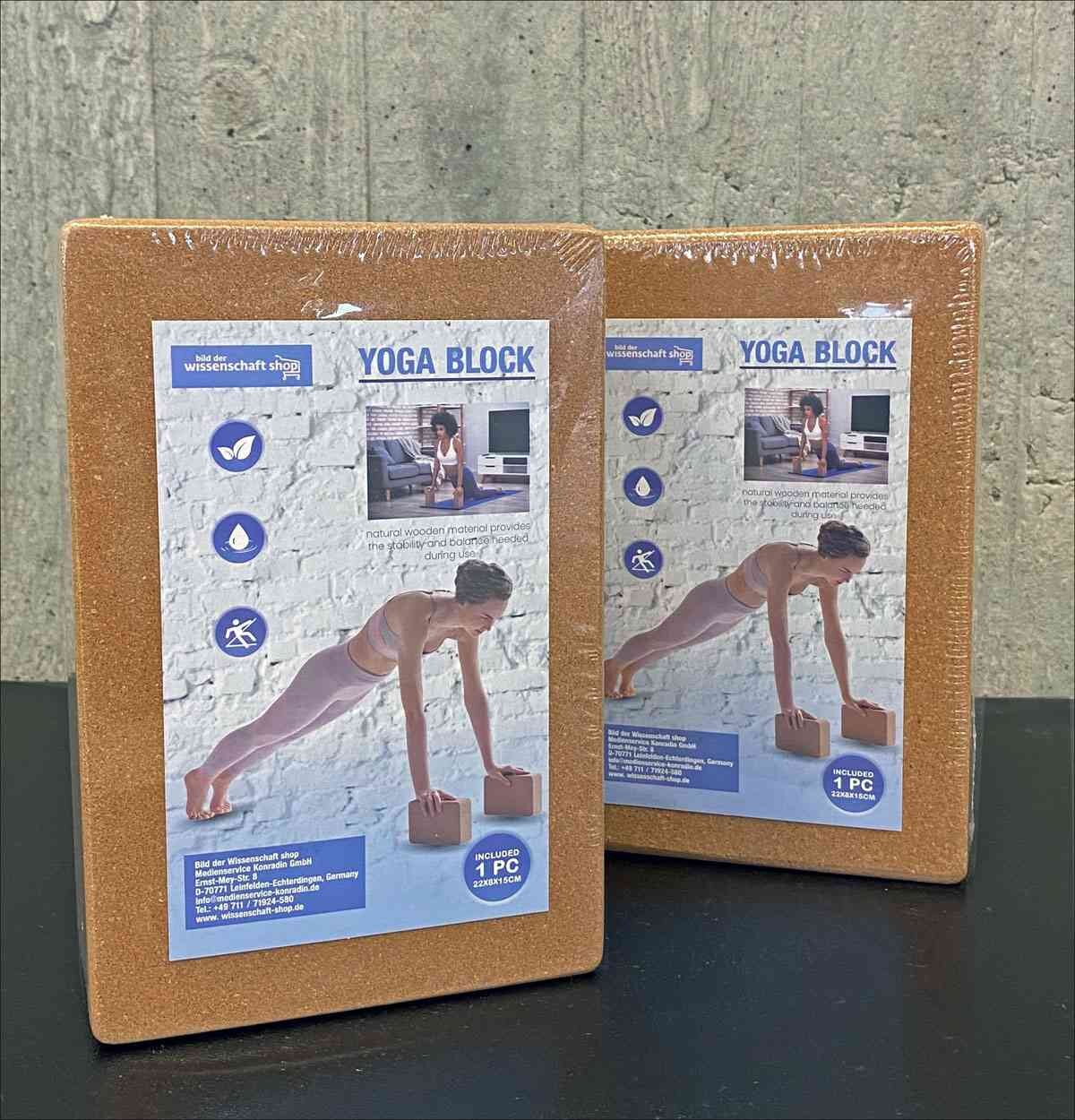 Zwei Yoga-Blocks in Verpackung mit Bild einer Frau beim Yoga-Übung, Icons und Produktinformationen.