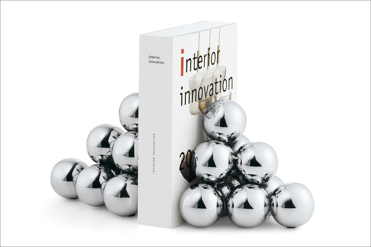 Buch mit "interior innovation" auf weißem Hintergrund, umgeben von silbernen, spiegelnden Kugeln.