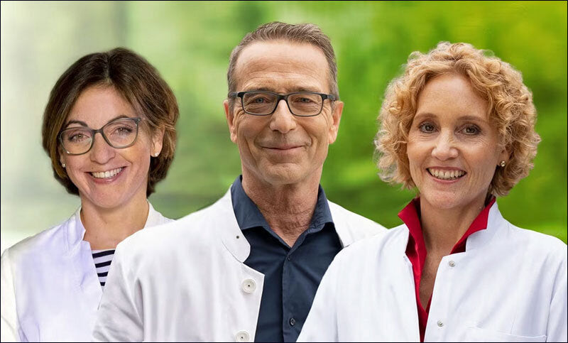 Drei Ärzte in weißen Kitteln vor grünem, unscharzem Hintergrund, lächelnd in die Kamera schauend.