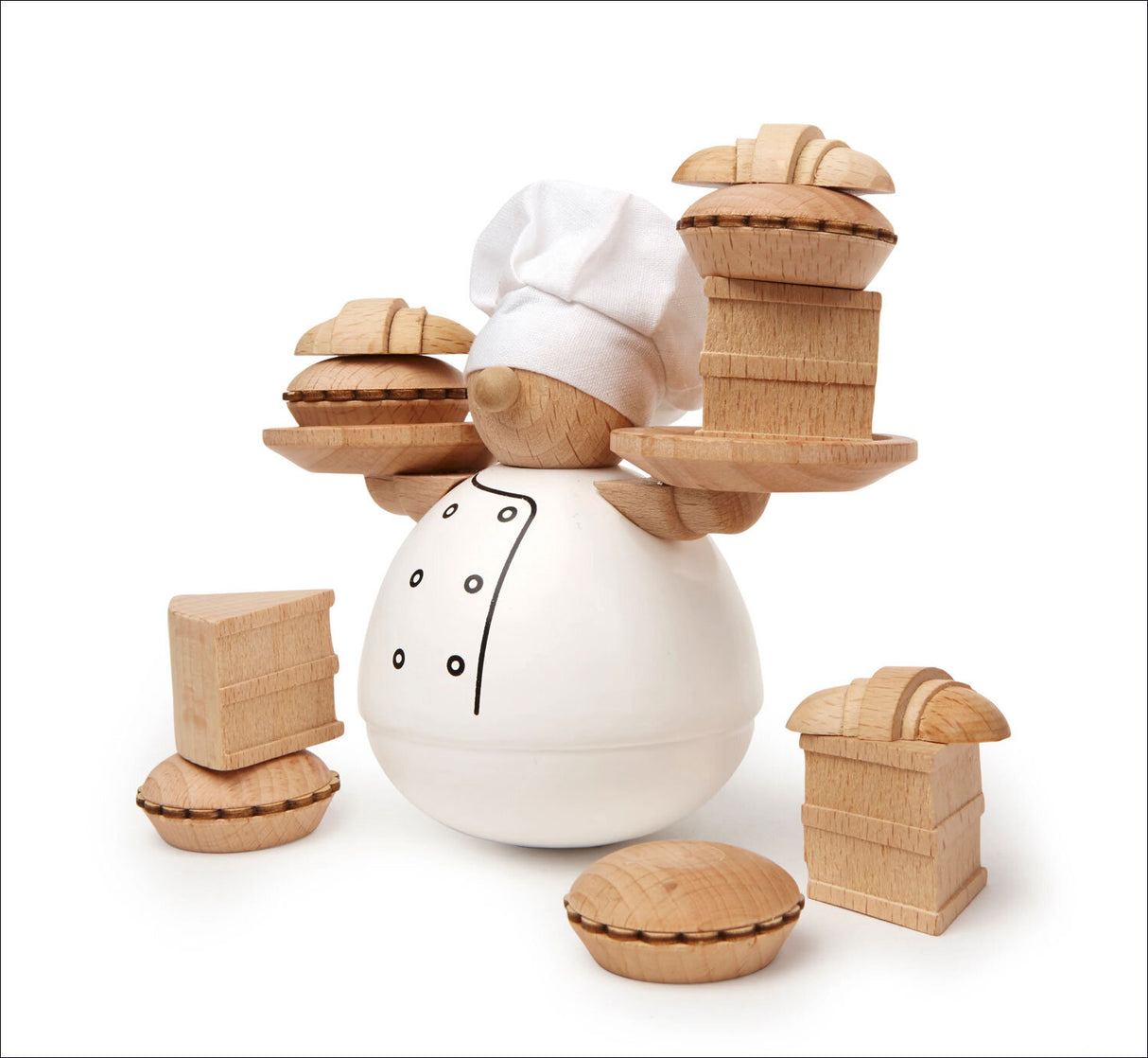 Holz-Kochfigur mit weißem Kochmütze, umgeben von Holz-Kuchenstücken auf weißem Hintergrund.