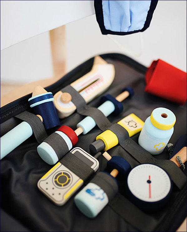 Spielzeug-Ärztetasche mit medizinischen Instrumenten und Zubehör in bunten Farben.
