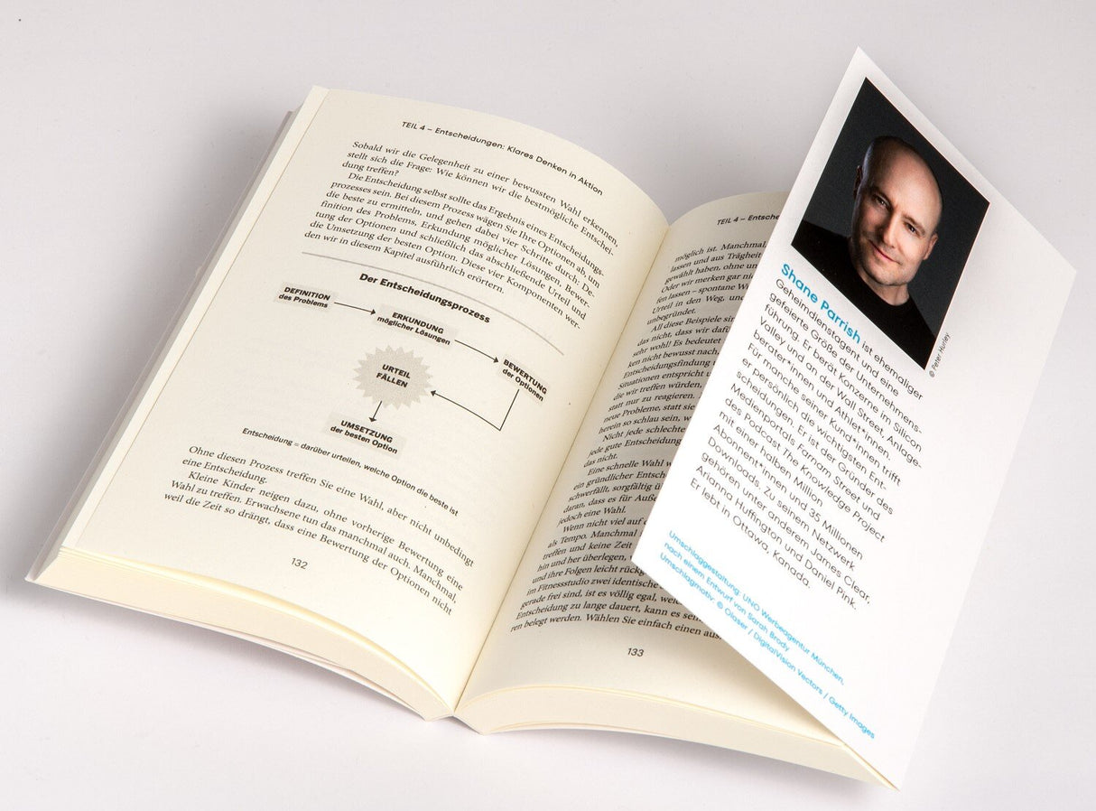 Offenes Buch mit Text, Diagramm und einer beigefarbenen Seite mit Foto und Text.