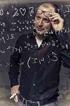 Frau steht vor Tafel mit mathematischen Formeln, denkt nach, hält Stift an Kopf.