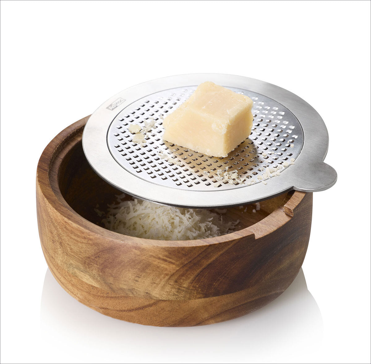 Block Hartkäse auf einer Metallreibe über einem Holzschüssel mit geriebenem Käse.