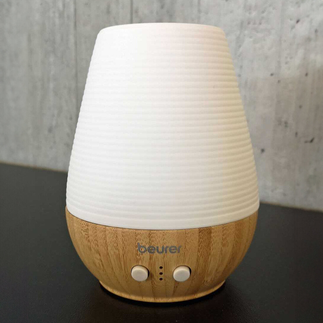 Luftbefeuchter mit Holzoptik, weißen Oberteil und zwei Bedientasten.