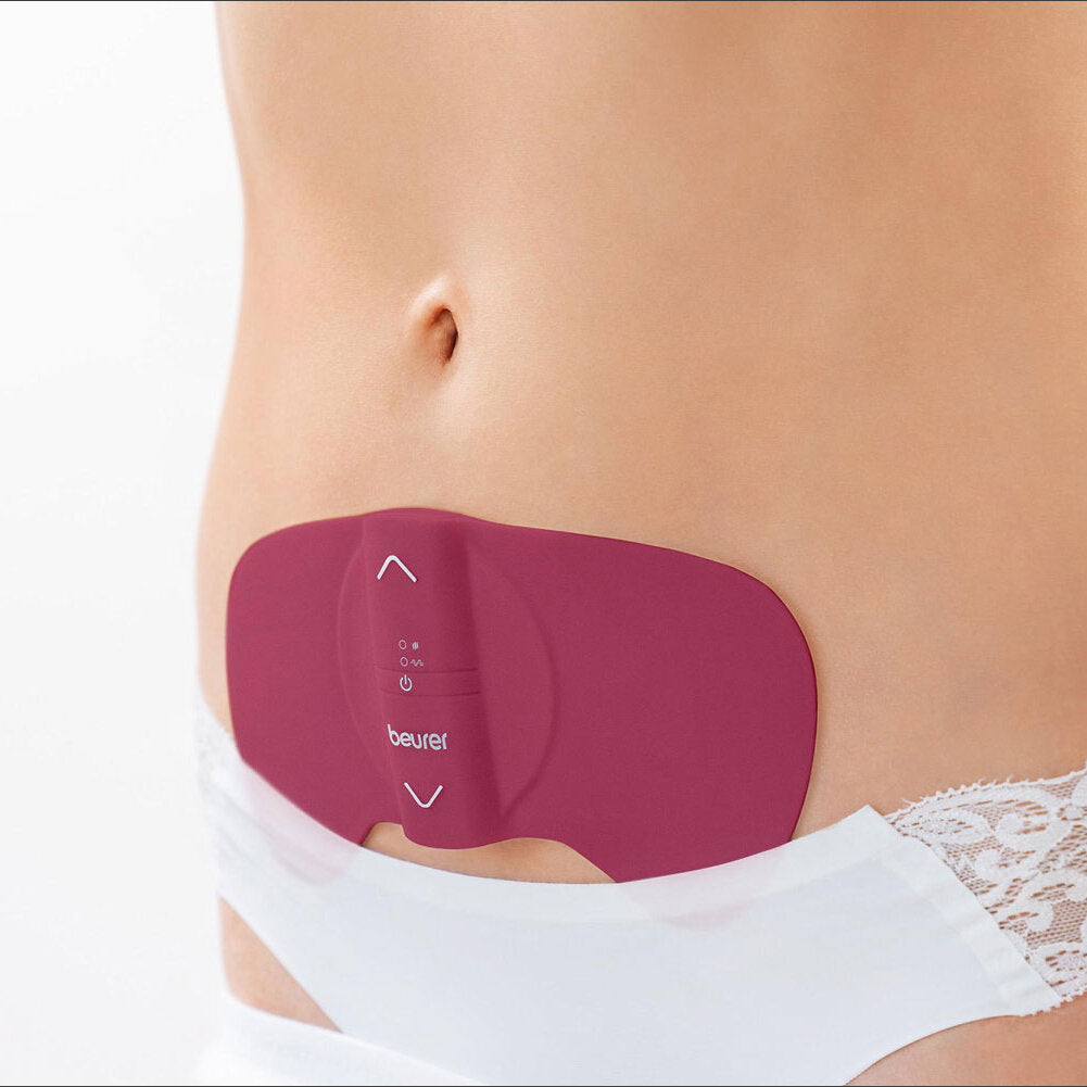 Schwangere Frau mit Bauch, trägt eine weiße Unterhose und eine rot-violette Wärmepackung auf dem Bauch.