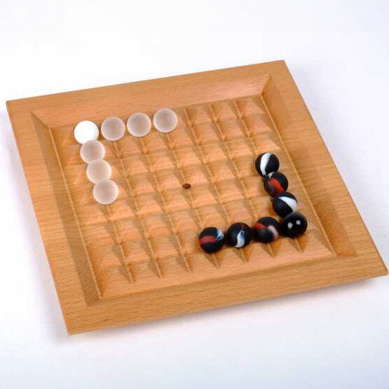 Holz-Board mit weißen und schwarzen Spielsteinen, die eine L-Form bilden.