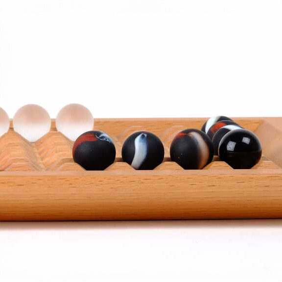 Holzspielbrett mit schwarzen und weißen Kugeln, einige Kugeln sind verschoben.