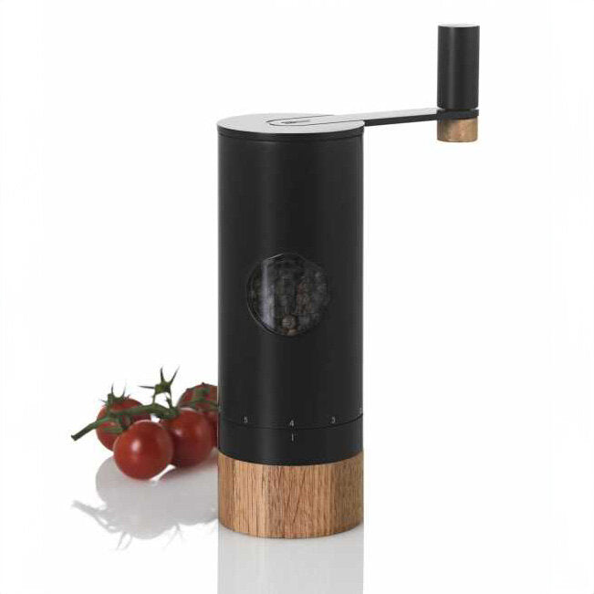 Elektrischer Mörser mit Handkurbel, daneben Tomaten auf einem weißen Hintergrund.