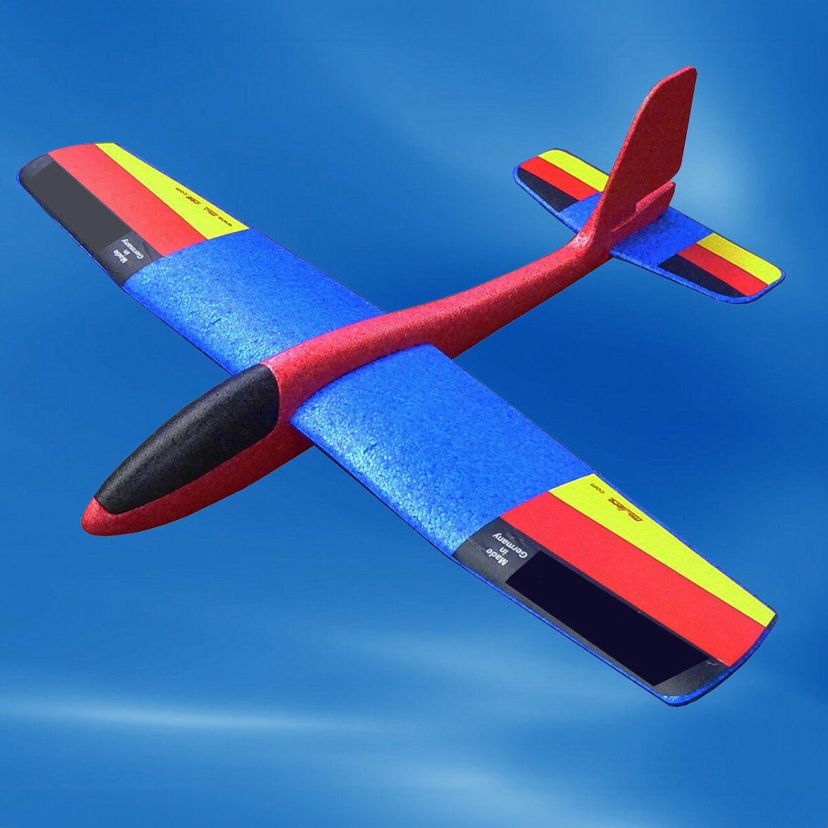 Fernsteuerbares Modellflugzeug mit blauen Flügeln, rotem Rumpf und bunten Flächen, fliegt am blauen Himmel.