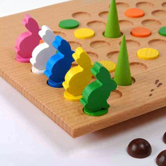 Holzspiel mit bunten Hasen-Figuren, grünen Spitzen und bunten Scheiben.