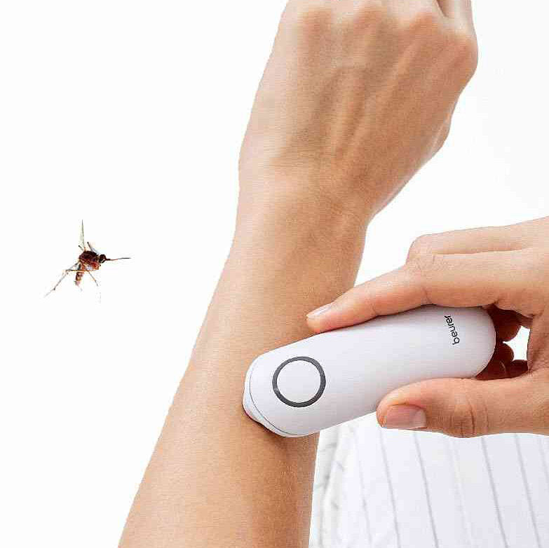 Hand hält elektrischen Insektenstich-Stichschutz gegen den Arm, Fliegen in der Luft.