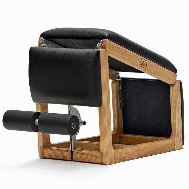 Pilates-Reformer mit Holzrahmen, schwarzen Polstern und einem Rollen- und Seilmechanismus.