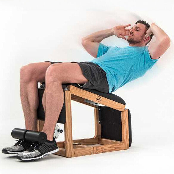 Mann liegt auf einem Trainingsgerät, hebt den Oberkörper, mit einer Hand an der Stirn und der anderen hinter dem Kopf.