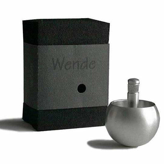 Schwarze Box mit "Wende" und einem schwarzen Punkt, daneben eine silberne Flasche mit Schraubverschluss.