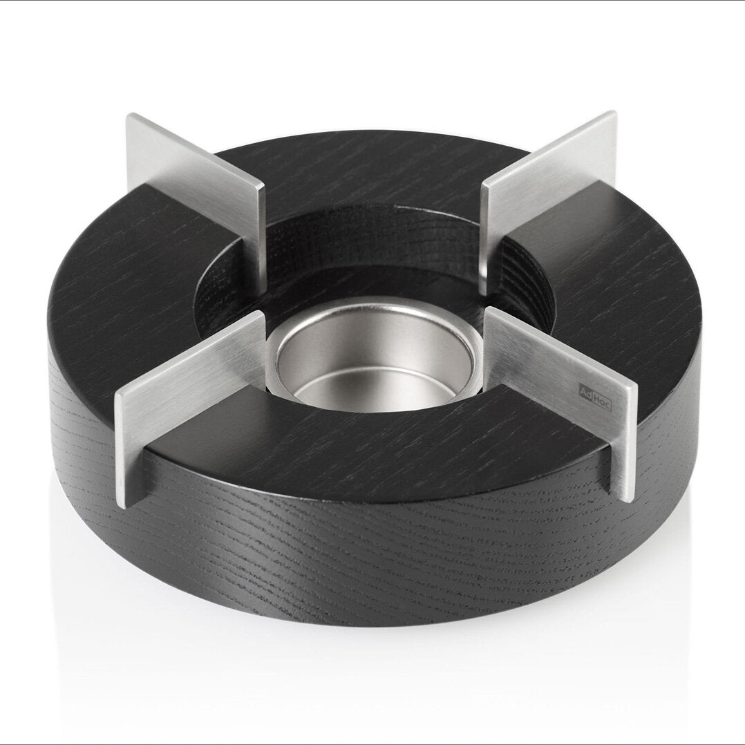 Runder Kochring mit vier Metallspießen, schwarzer Boden, silberner Rand, auf weißem Hintergrund.